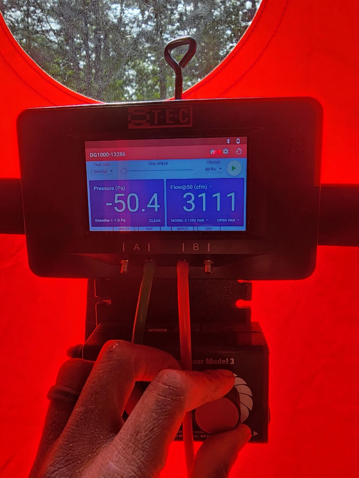 Horizon Homes technician using a blower door to test air leakage in a Portland Maine home