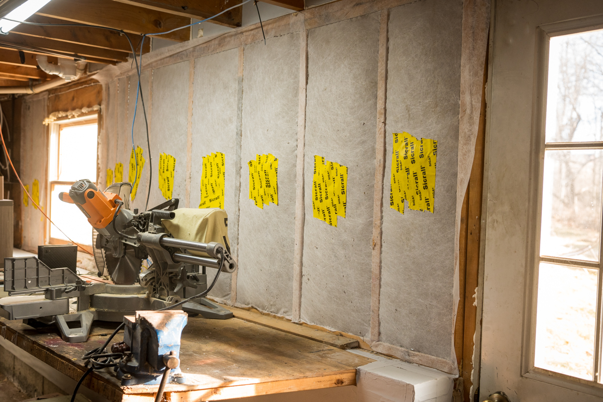 Horizon Homes technician measuring attic insulation depth in a Maine home during an energy assessment