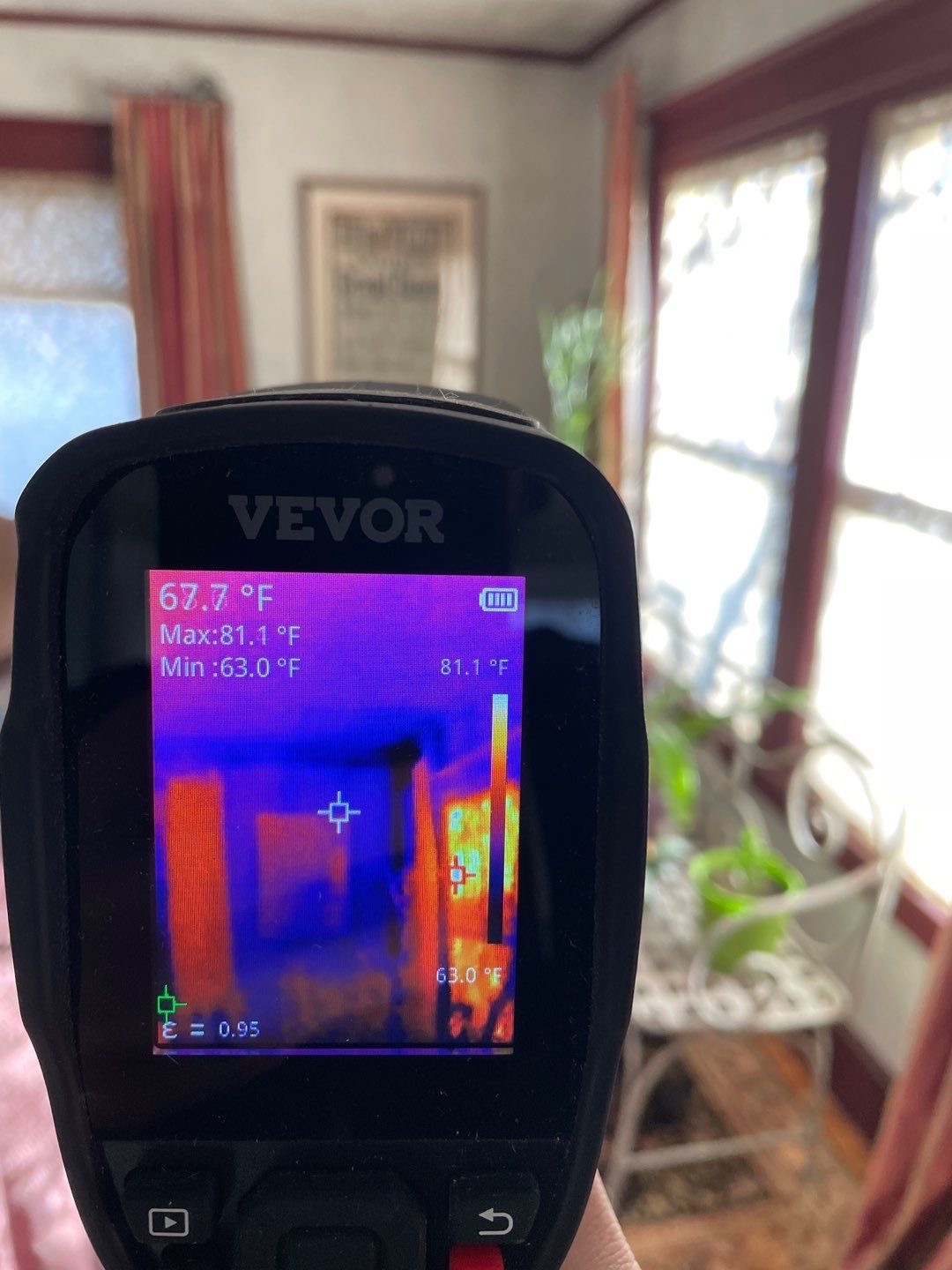 Thermal imaging camera showing heat loss patterns during a home energy audit in Maine