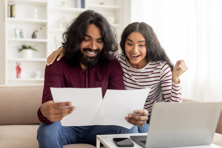 Efficiency Maine insulation rebate paperwork with blown cellulose insulation being installed in attic