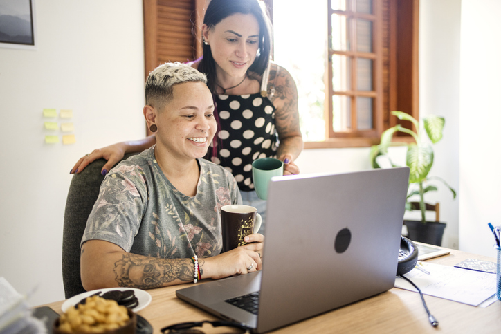 Smiling young couple using laptop at home